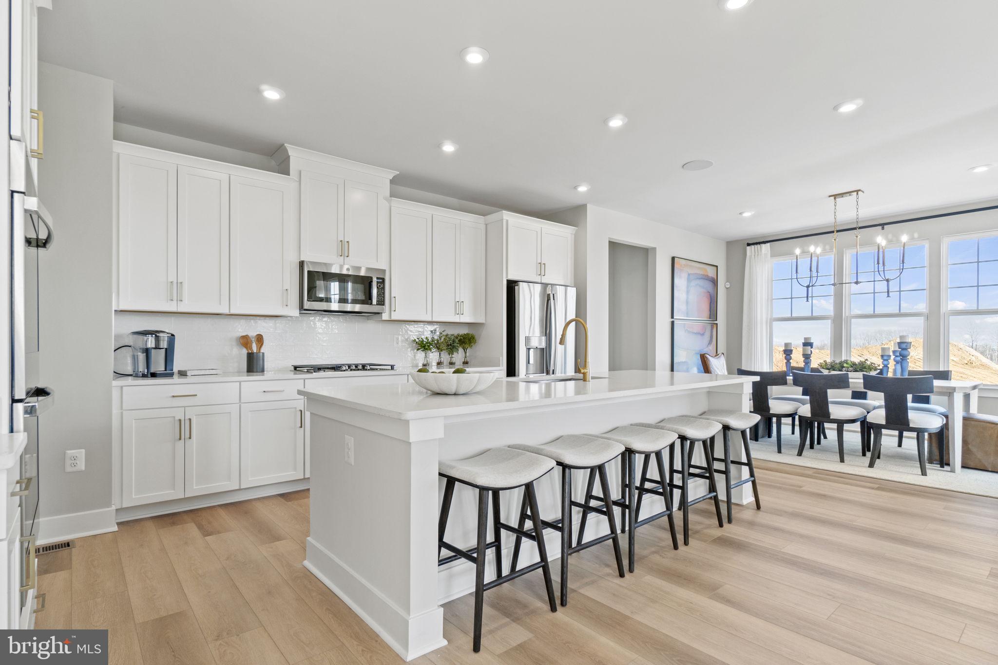 a kitchen with appliances a sink a counter top space and a center island