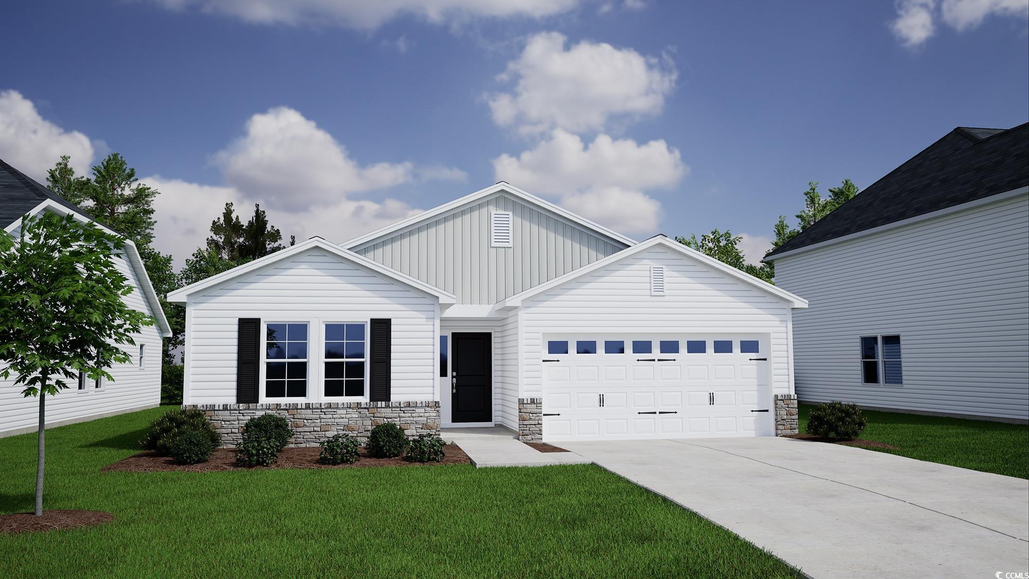 View of front of home with a front yard and a gara