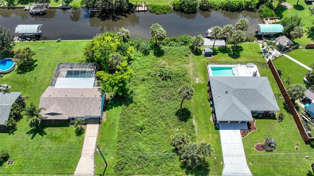 an aerial view of a house with a yard and lake view