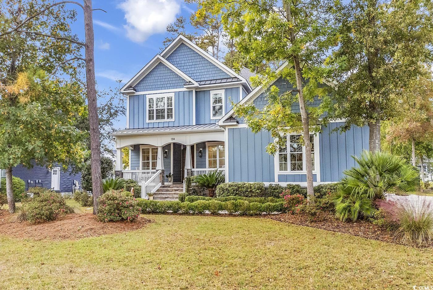 Craftsman house with a front lawn and covered porc