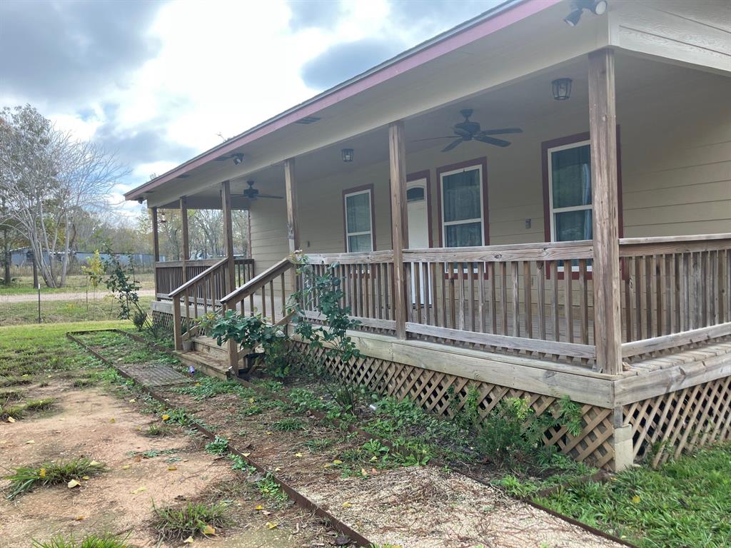 a view of a house with wooden deck and a small yard