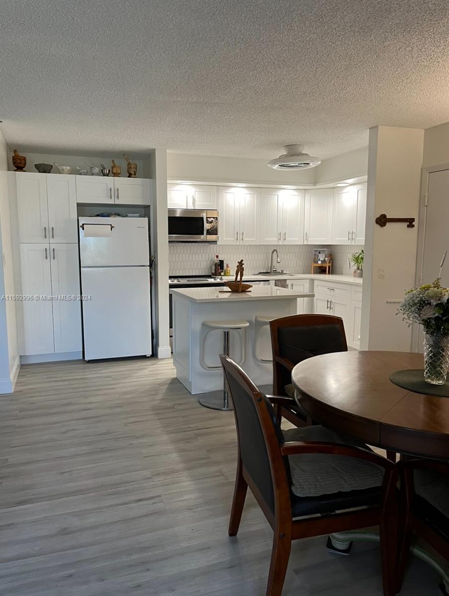 a kitchen with kitchen island a table and chairs in it