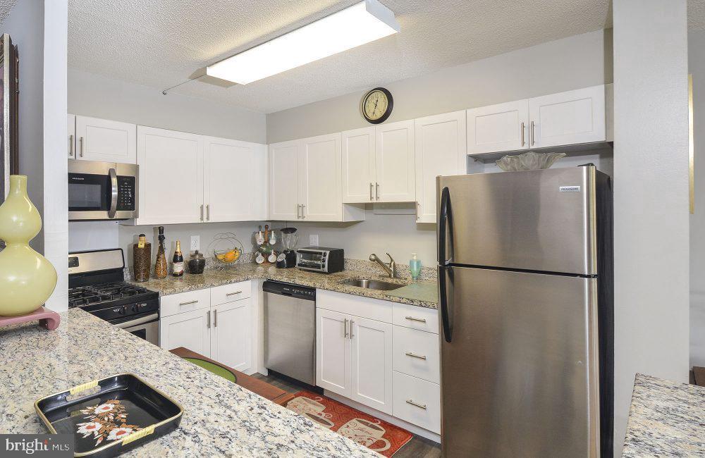 a kitchen with a refrigerator a stove a microwave and cabinets