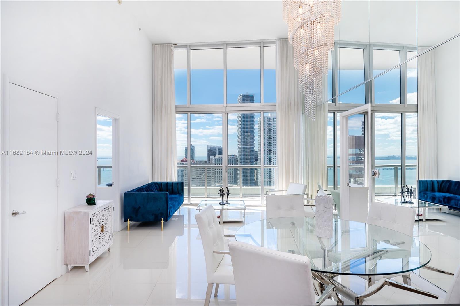 a dining room with furniture and large windows