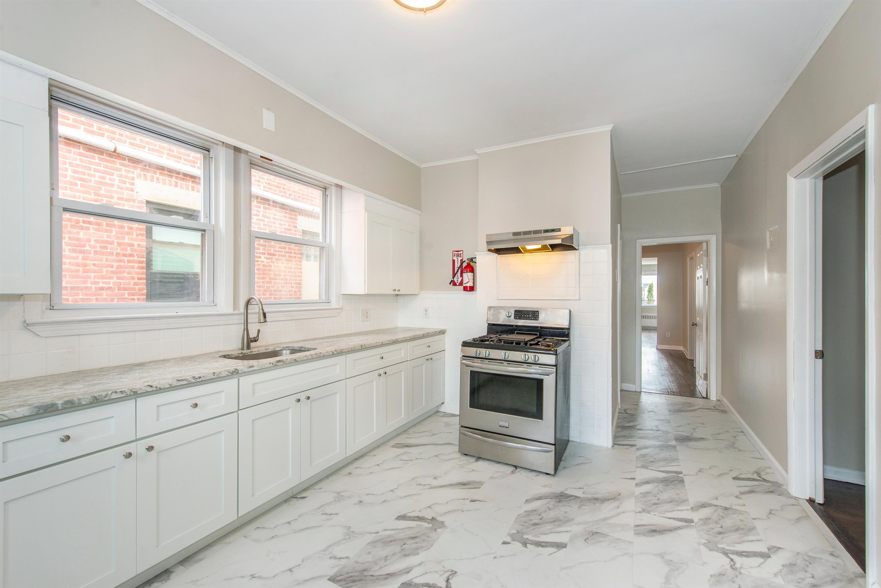 a kitchen with granite countertop a stove a sink and a refrigerator