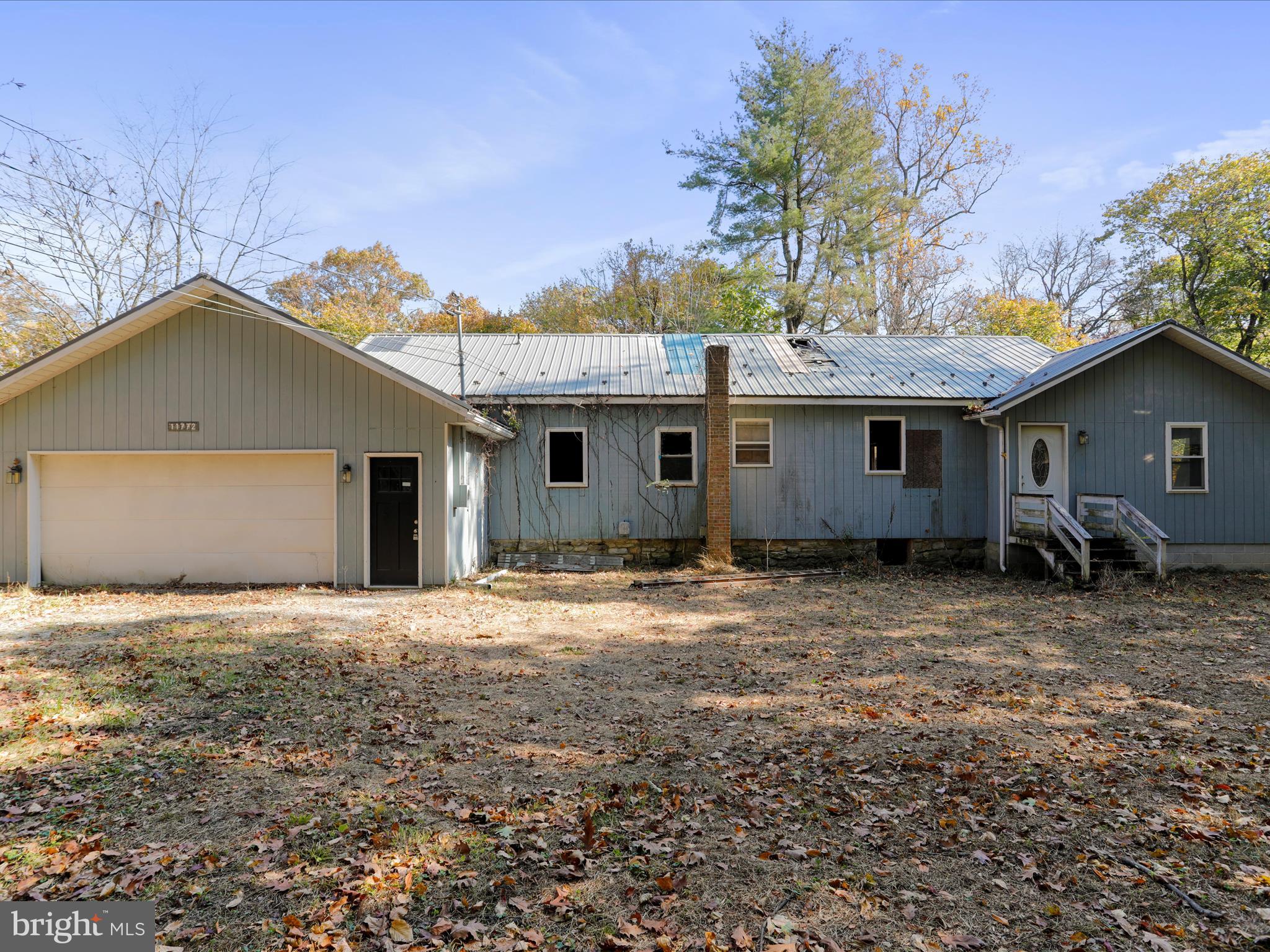 a front view of house with yard and trees in the background