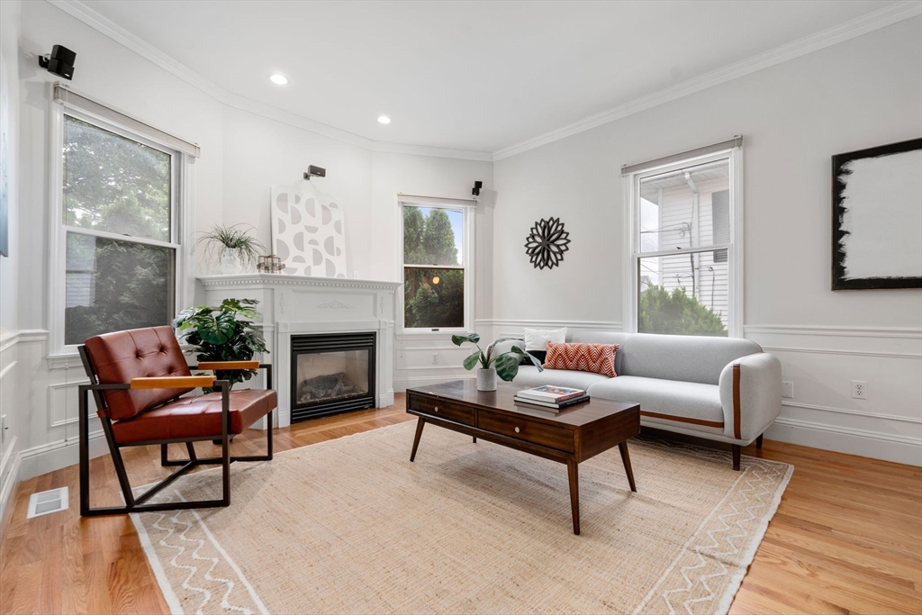 a living room with furniture a fireplace and a large window