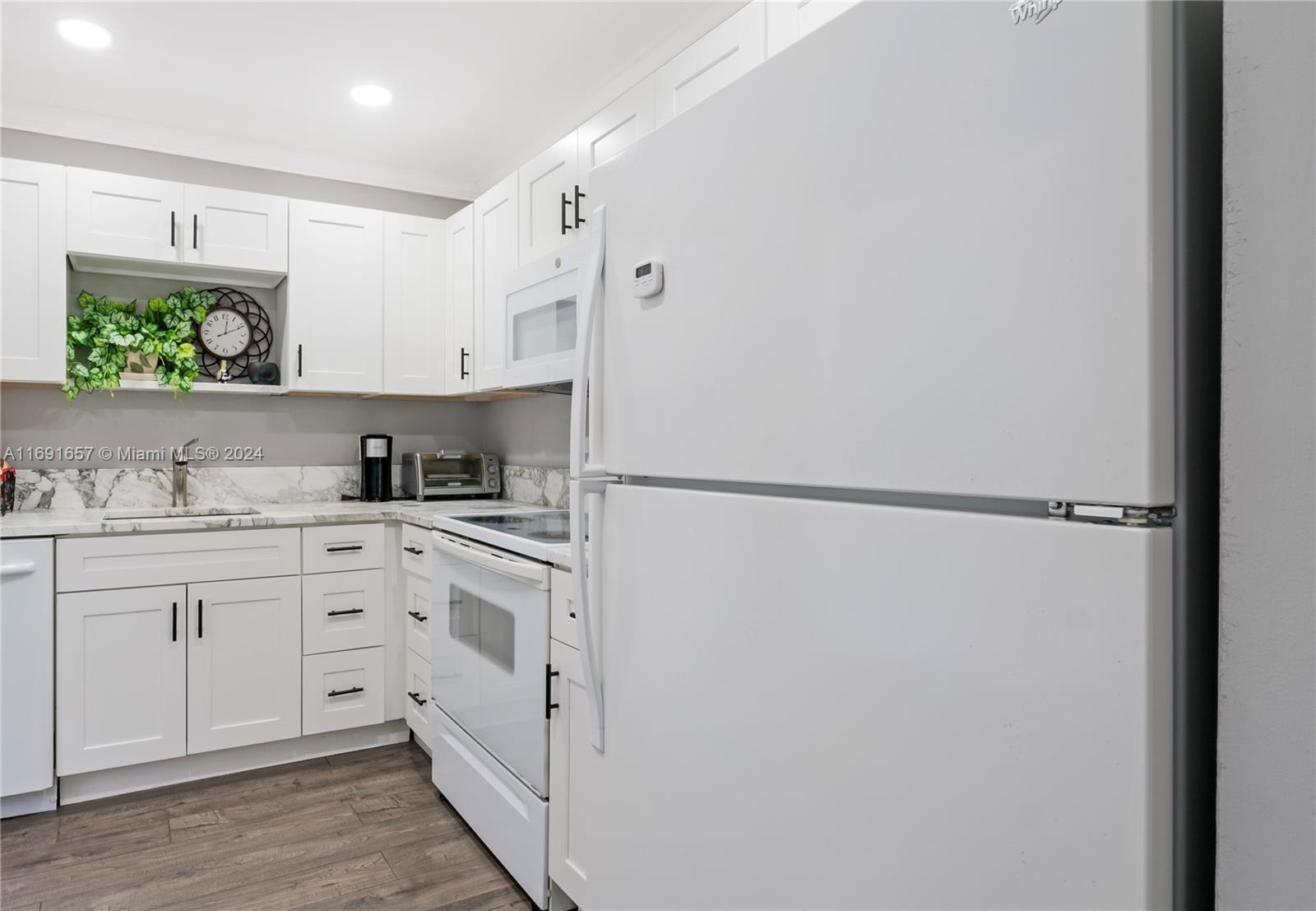 a kitchen with white cabinets and white appliances