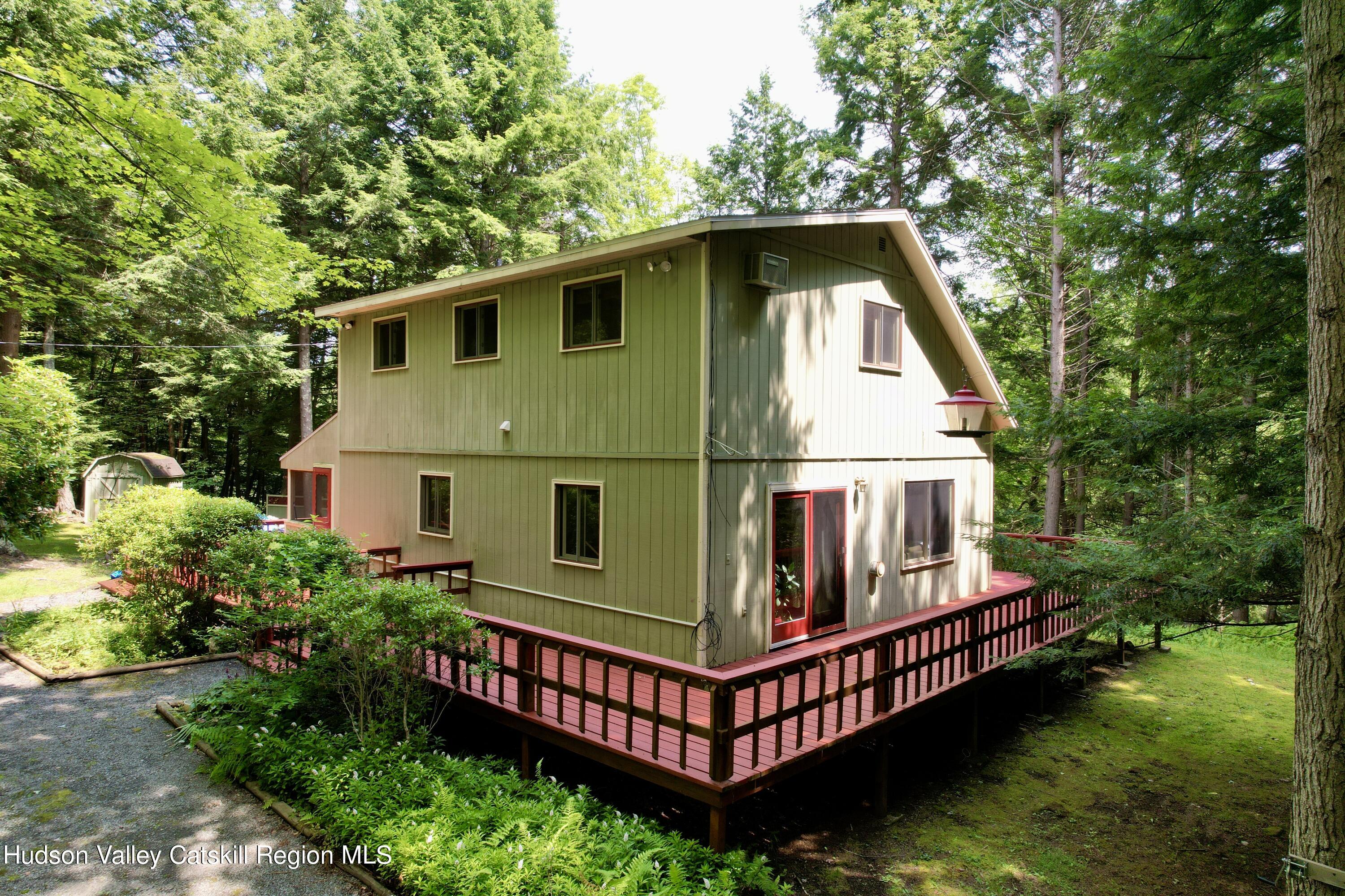 a view of backyard with deck and trees