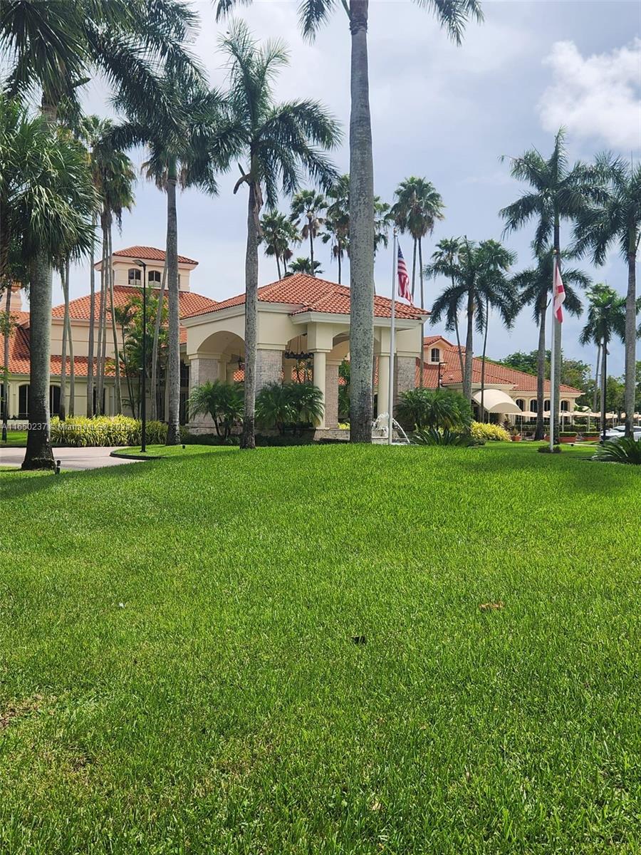 a front view of multi story residential apartment building with yard and green space