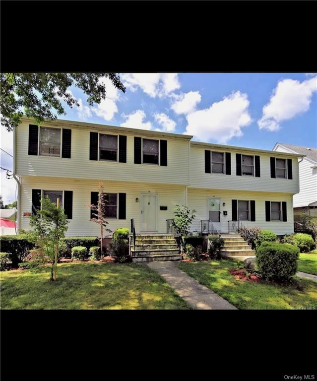 a front view of a house with a garden and yard