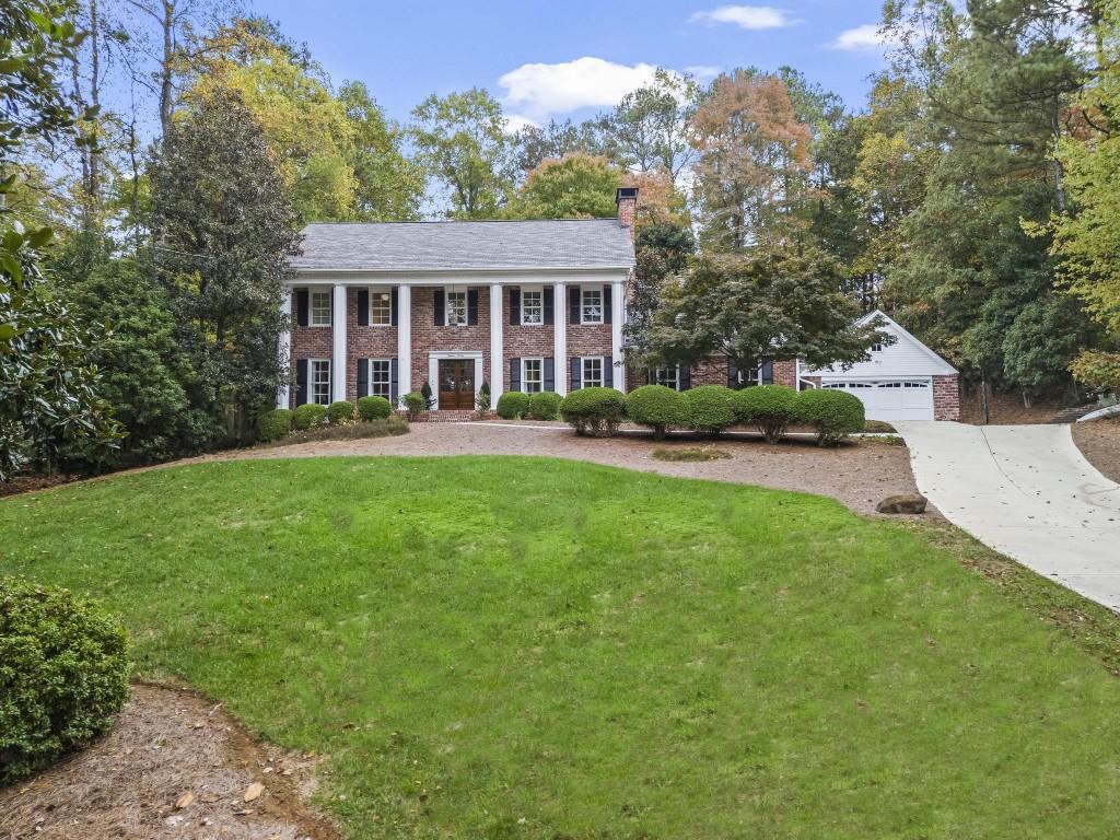 a front view of a house with a yard and trees