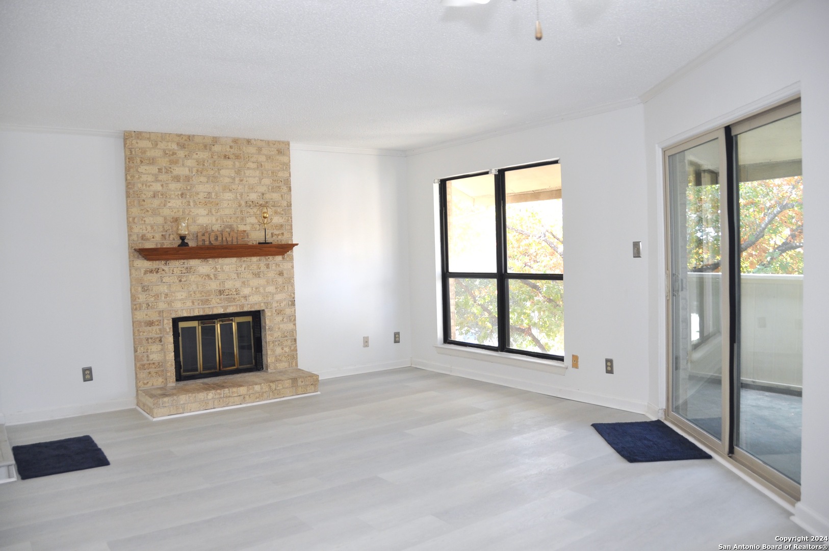 a view of an empty room with a fireplace and a window