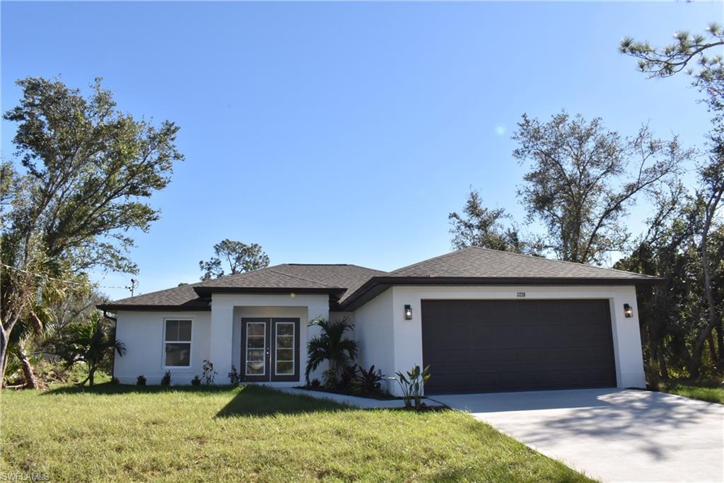 View of front of house with a garage and a front lawn