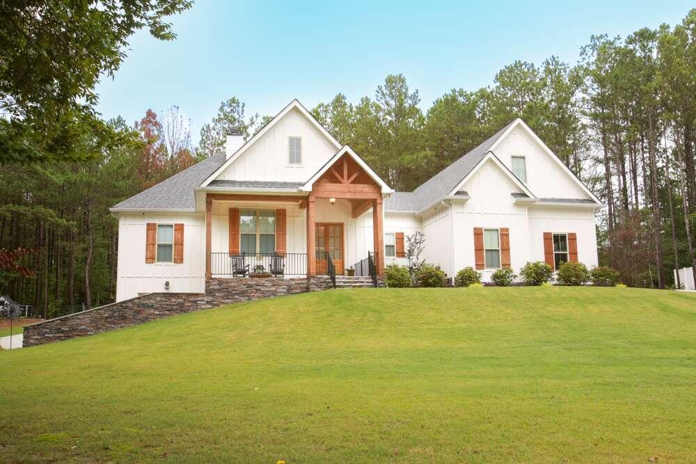 a view of a house with a big yard and large trees