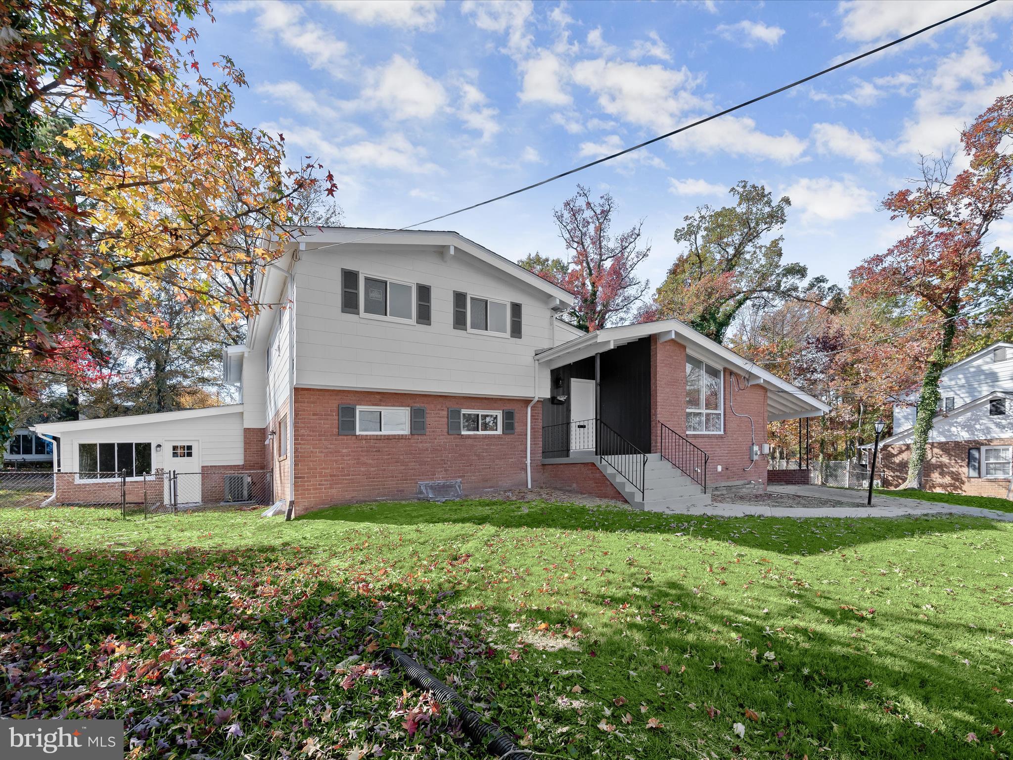 a brick house with a big yard and large trees