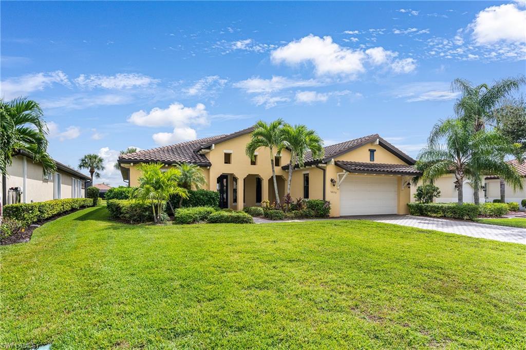 Mediterranean / spanish-style home featuring a garage and a front yard