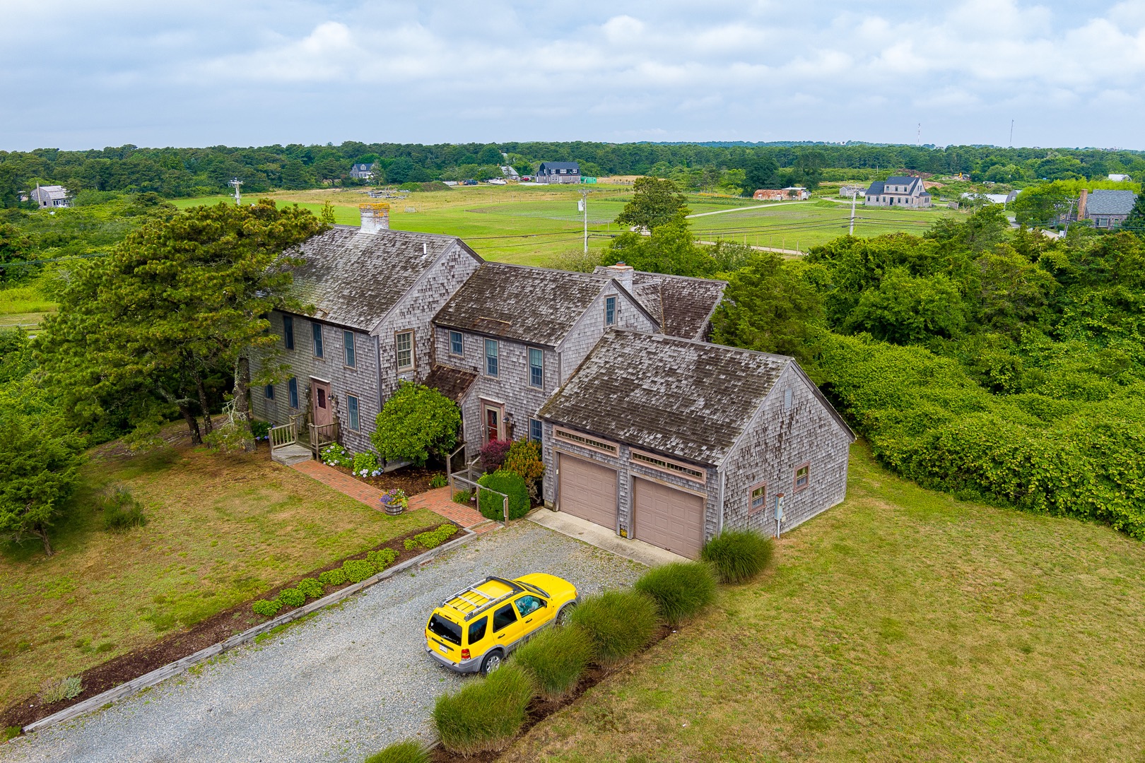 a view of a house with big yard and large trees