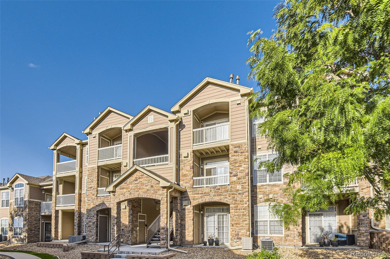 a front view of a residential apartment building with a yard