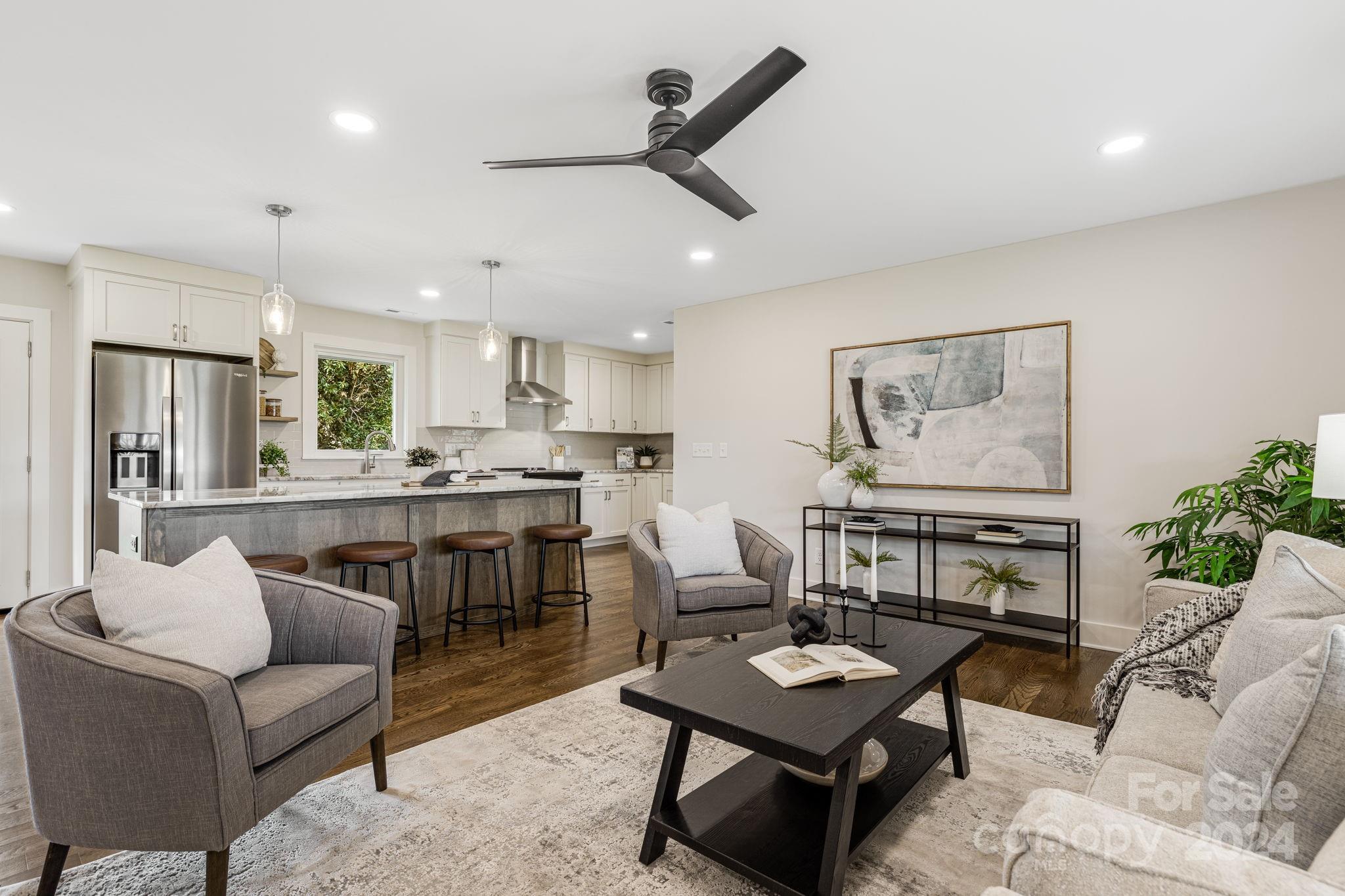 a living room with furniture kitchen view and a potted plant