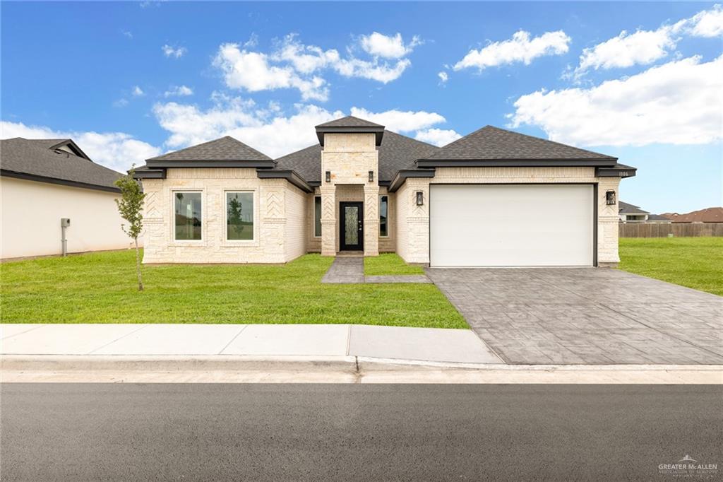 a front view of a house with a yard and garage