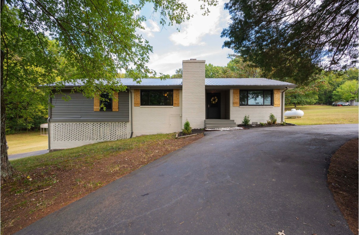 a view of a house with a backyard and a tree