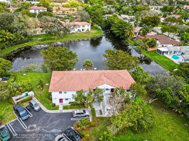 an aerial view of a house with garden space and lake view