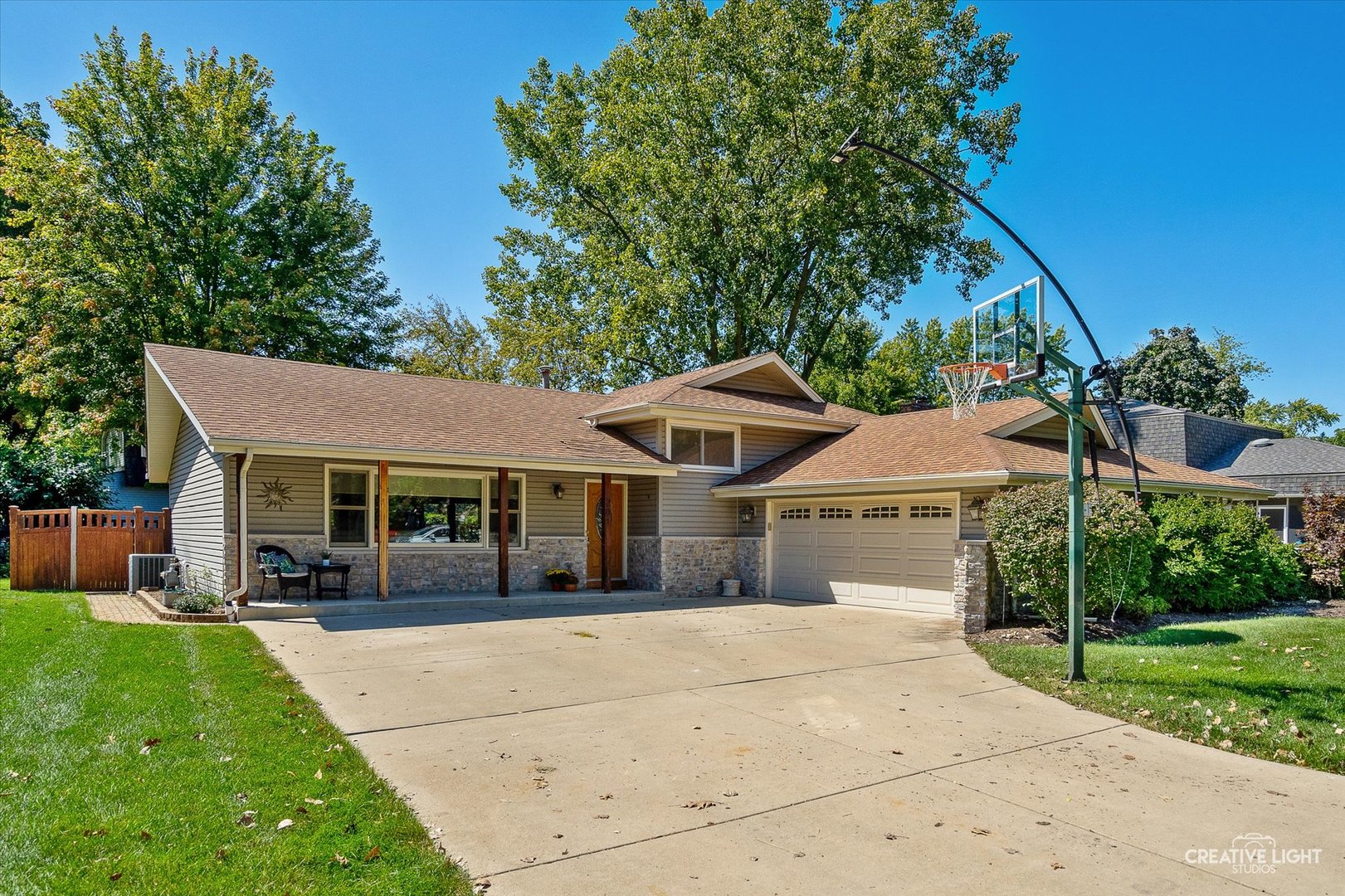 a front view of a house with a garden and trees