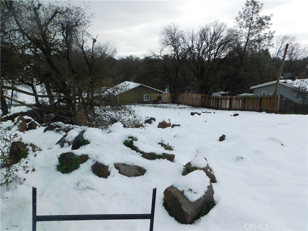 a view of white house with a yard covered in snow