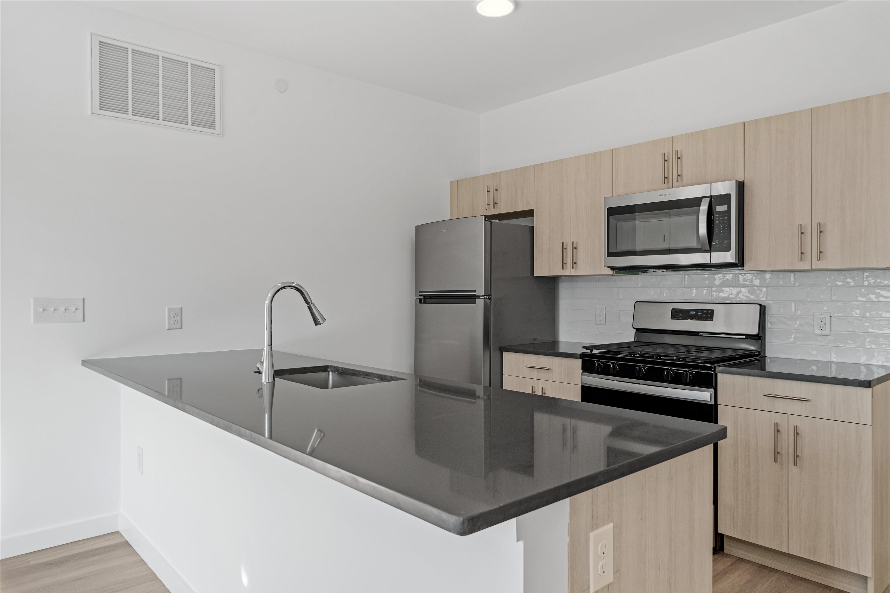 a kitchen with stainless steel appliances granite countertop a sink and a microwave