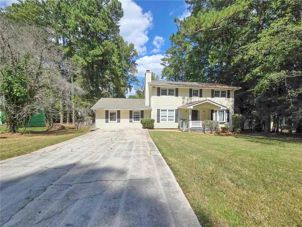 a front view of a house with a yard and trees