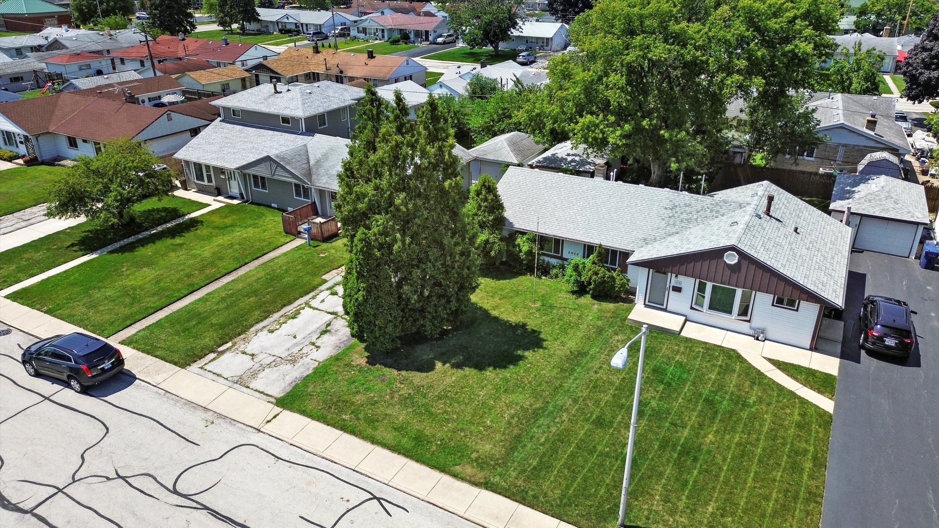 an aerial view of a house with a garden and trees