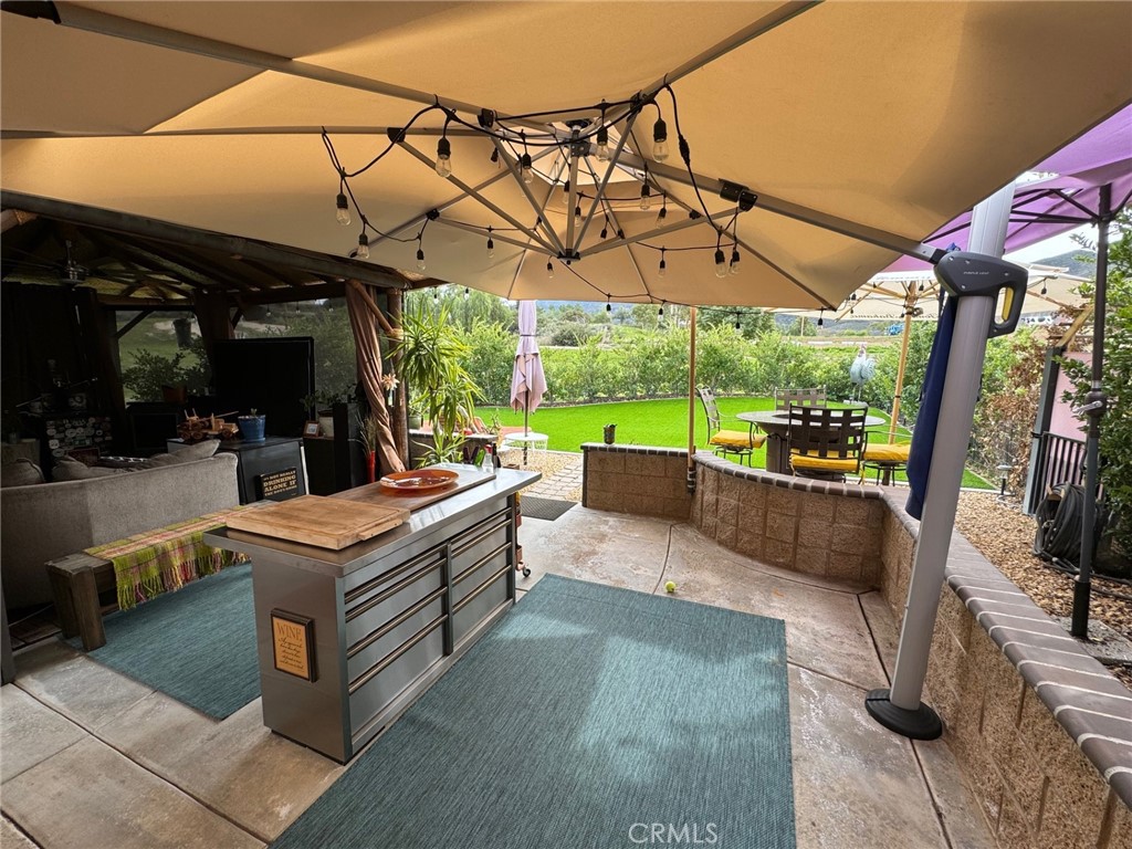 a view of a patio with a table and chairs under an umbrella