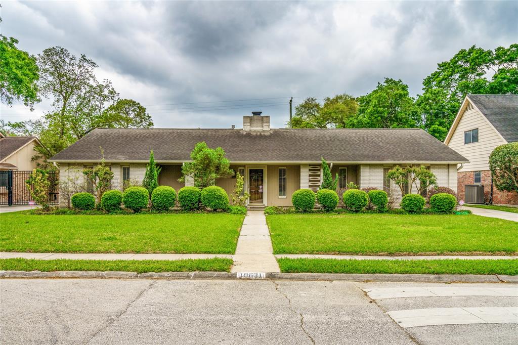 a front view of a house with a yard and potted plants