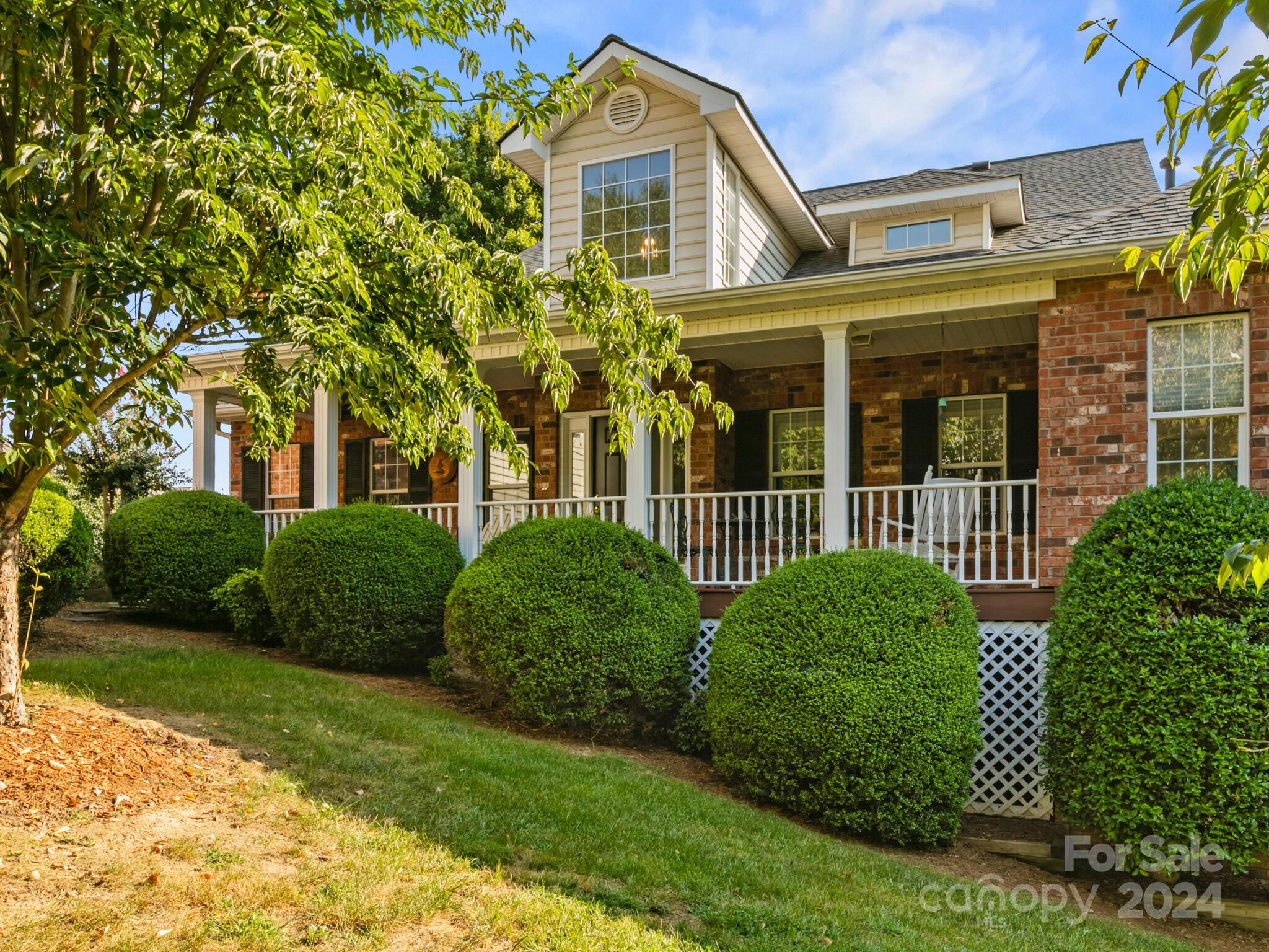 front view of a brick house with a yard