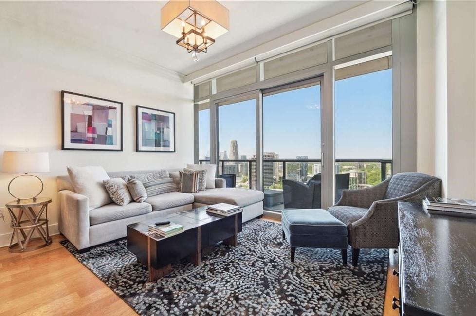 a living room with furniture large window and a table