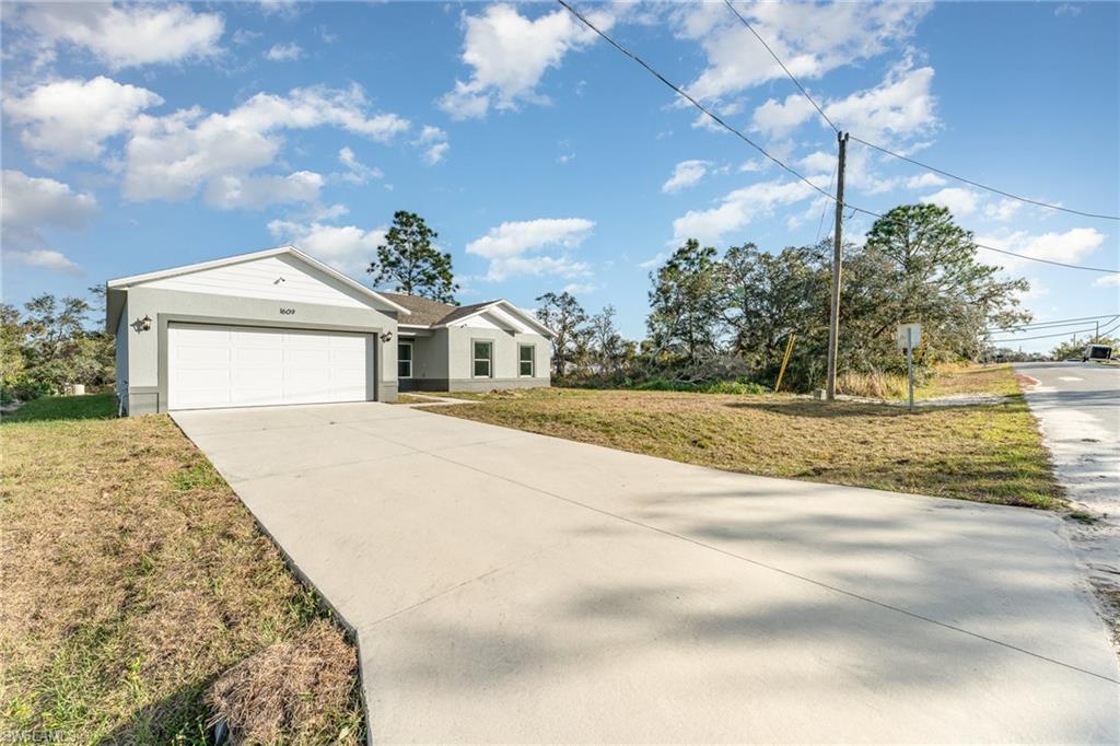 View of front of house with a garage and a front lawn