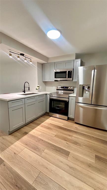 An open kitchen fully equipped with stainless steel stove, microwave and refrigerator.