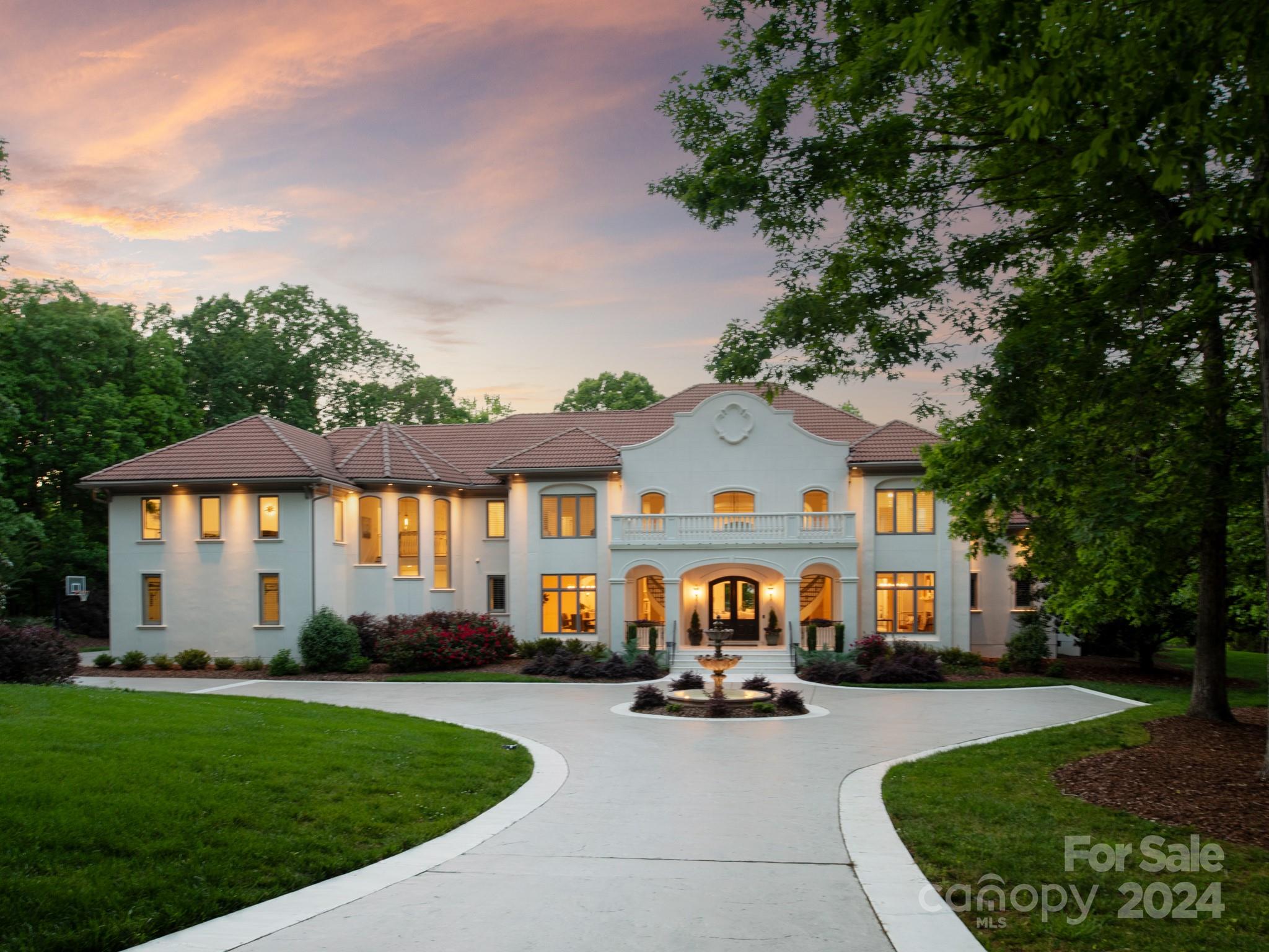 a front view of a house with a garden and a tree