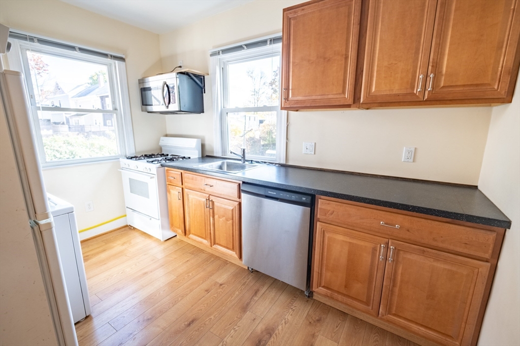 a kitchen with granite countertop wooden cabinets a sink and a window