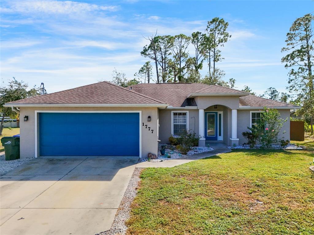 a front view of a house with yard and garage