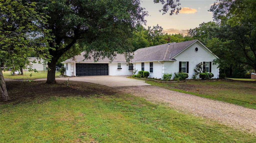 a front view of a house with a yard and trees