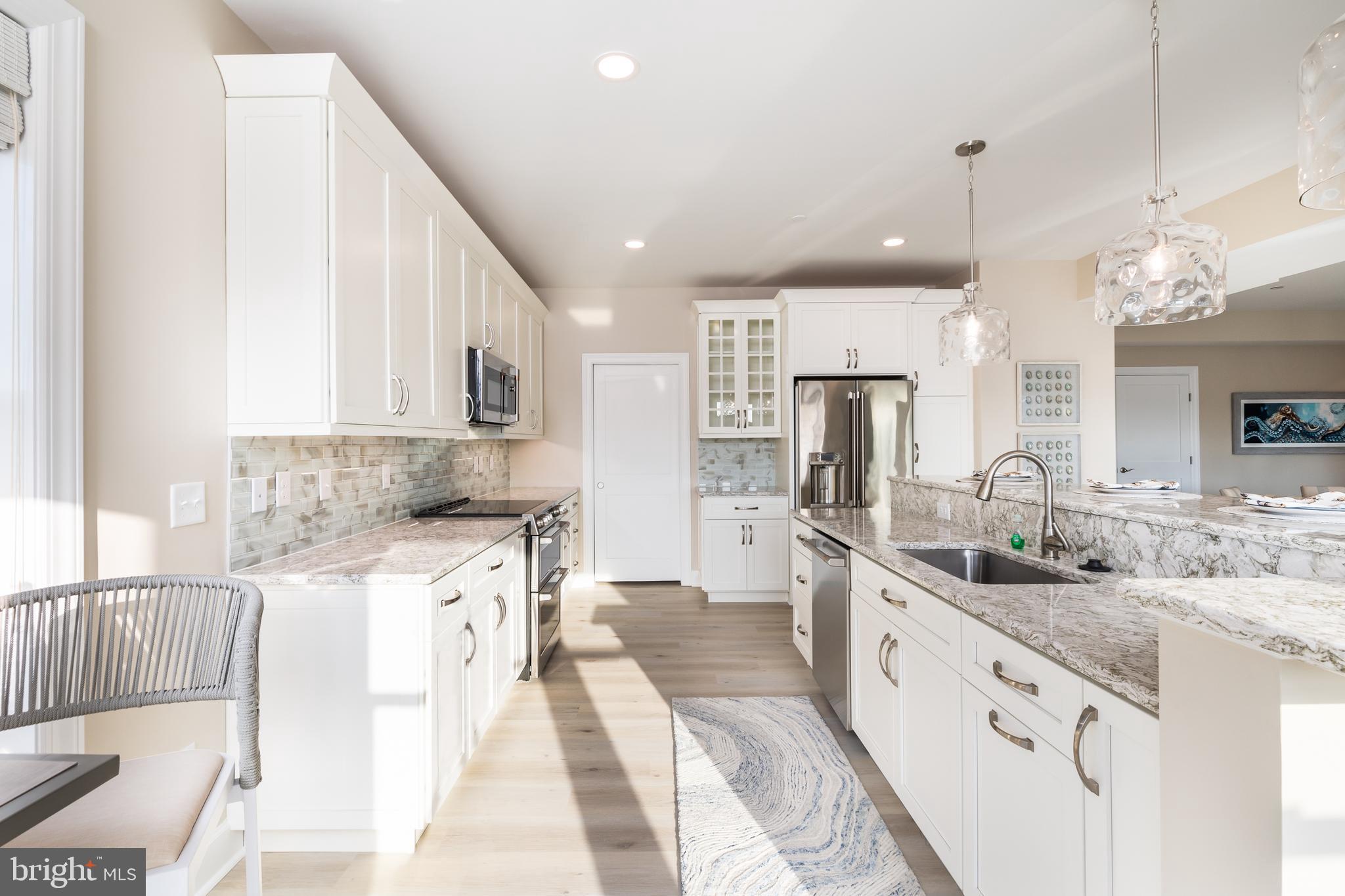 a large kitchen with stainless steel appliances kitchen island granite countertop a sink and cabinets