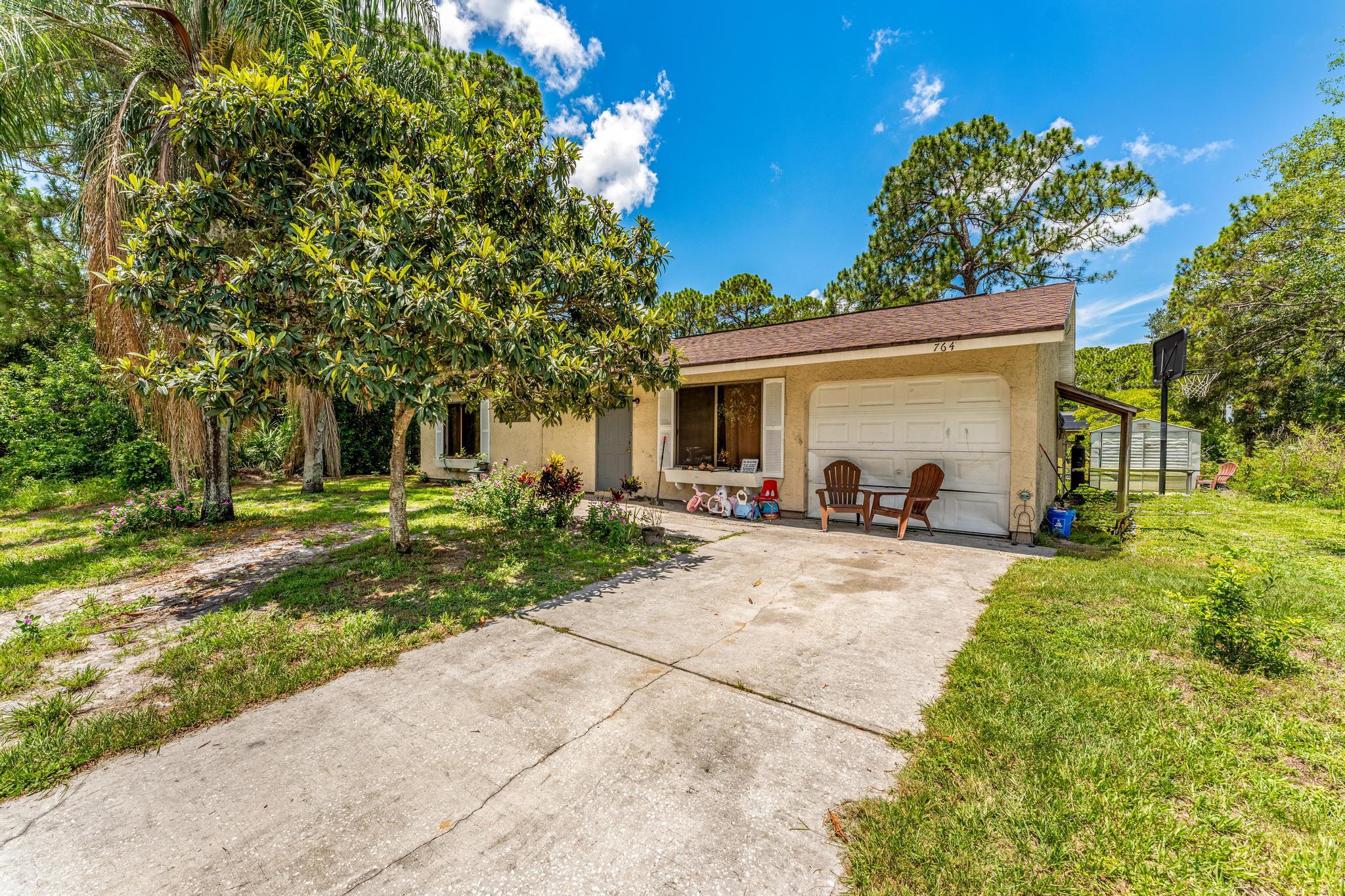 a view of a house with backyard and a tree