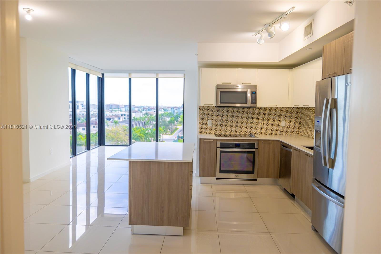 a kitchen with granite countertop a refrigerator and a stove top oven