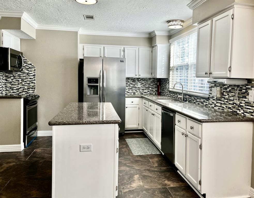 a kitchen with a stove sink and refrigerator