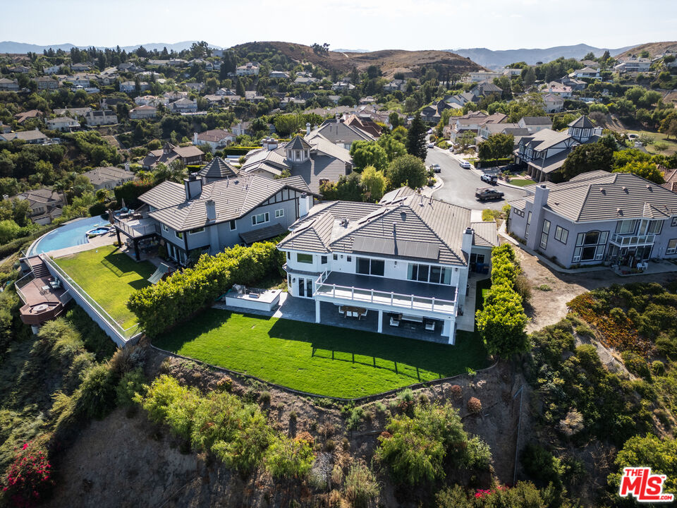 an aerial view of a house with a garden and mountain view