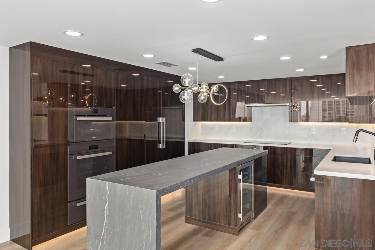 a large kitchen with a large counter top stainless steel appliances and cabinets