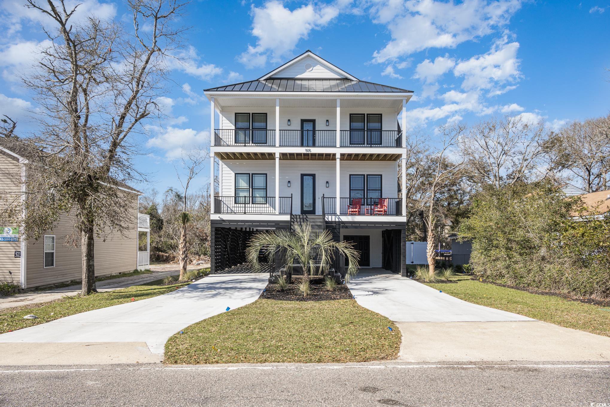 Coastal home with a carport, a balcony, and a fron