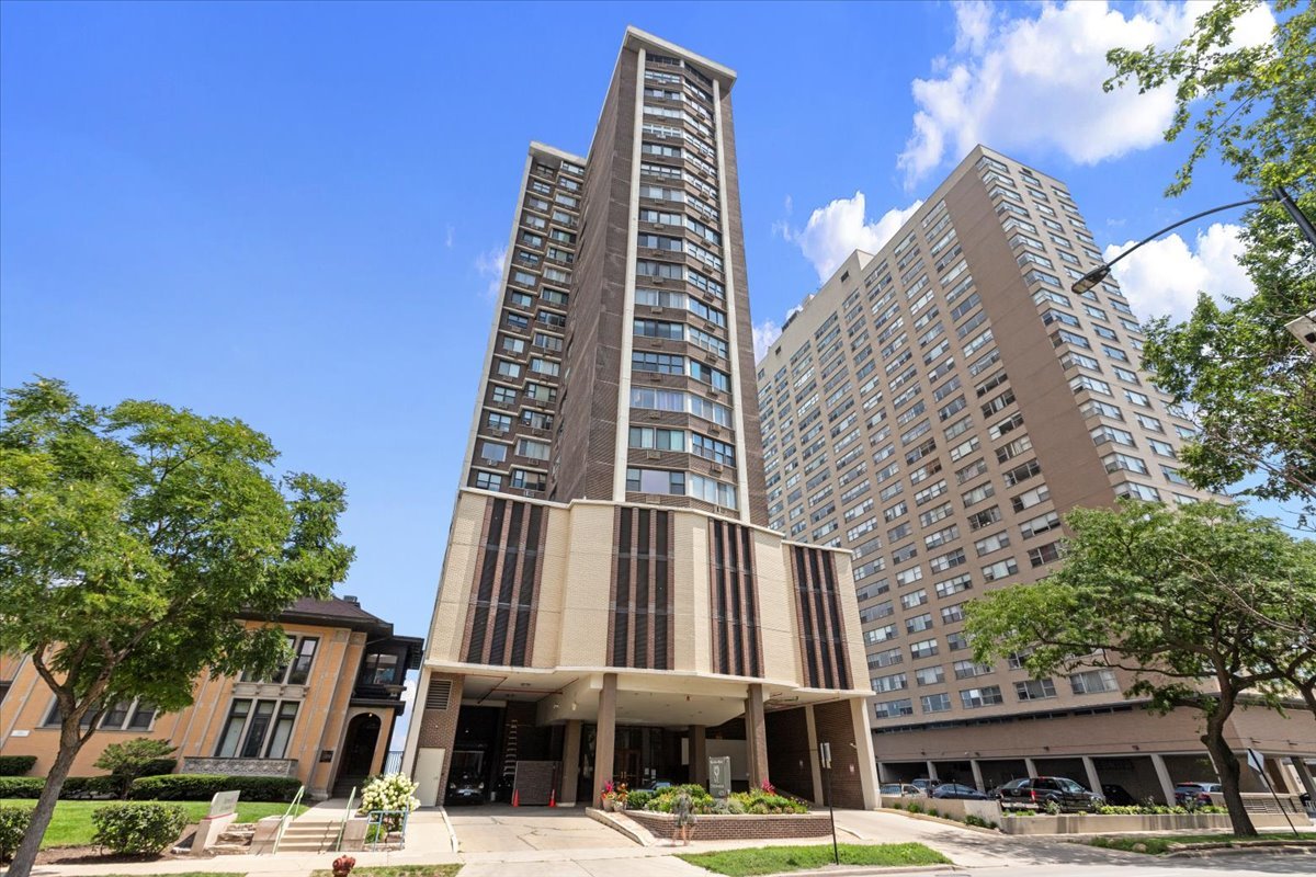 a front view of a building with streets and trees